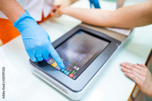 Medical Procedure. Woman Scanning Veins With Vein Finder photo