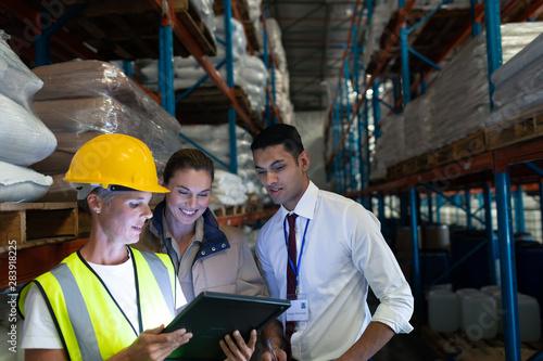 Warehouse staffs discussing over digital tablet in warehouse