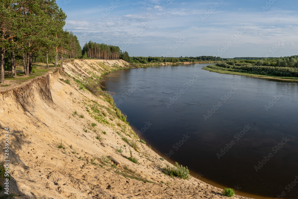 riverbank, high sandy cliff and forest on the shore