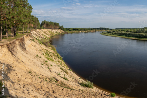 riverbank, high sandy cliff and forest on the shore