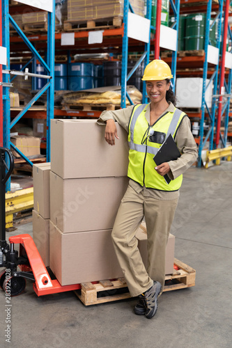 Female staff smiling while standing in warehouse