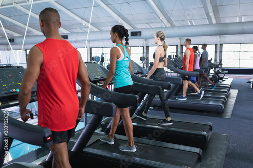 Fit people exercising on treadmill in fitness center