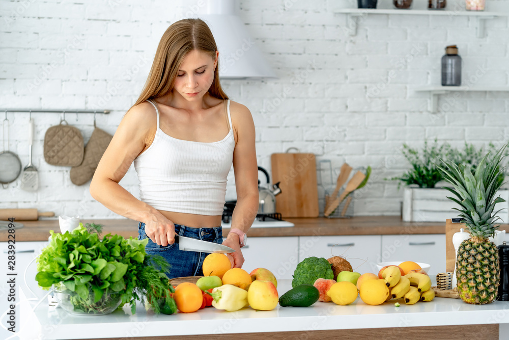 Cute healthy girl with fruits and vegetables in kitchen. Healthy food and Dieting concept Cute healthy girl with fruits and vegetables in kitchen. Healthy food and Dieting concept
