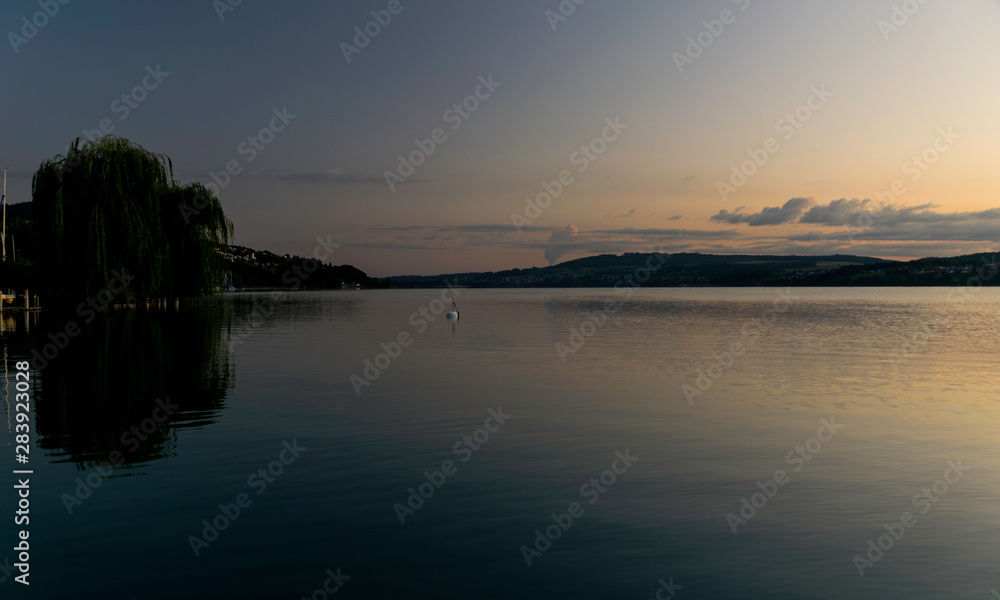 early morning on the lake, the chair, the silhouettes of the mountains early morning on the lake, the chair, the silhouettes of the mountains