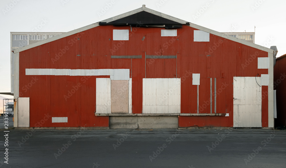 Red warehouse wall with closed gates