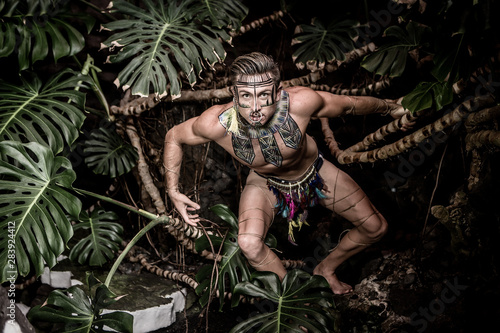 Male in loincloth climbing tropical tree