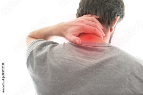 rear view of man suffering from neck pain photo