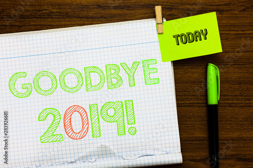 Writing note showing Goodbye 2019. Business photo showcasing New Year Eve Milestone Last Month Celebration Transition Open notebook page markers holding paper heart wooden background photo