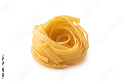 Rolled tagliatelle shape of italian pasta on whte background isolated