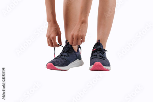 sporty fitness woman in sportswear tying shoelace on white background. healthy sport lifestyle