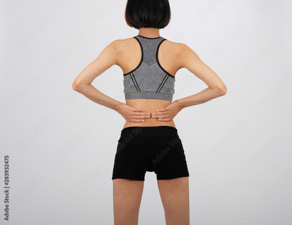 sporty fitness woman in sportswear with back pain on white background. sporty fitness woman in sportswear with back pain on white background.