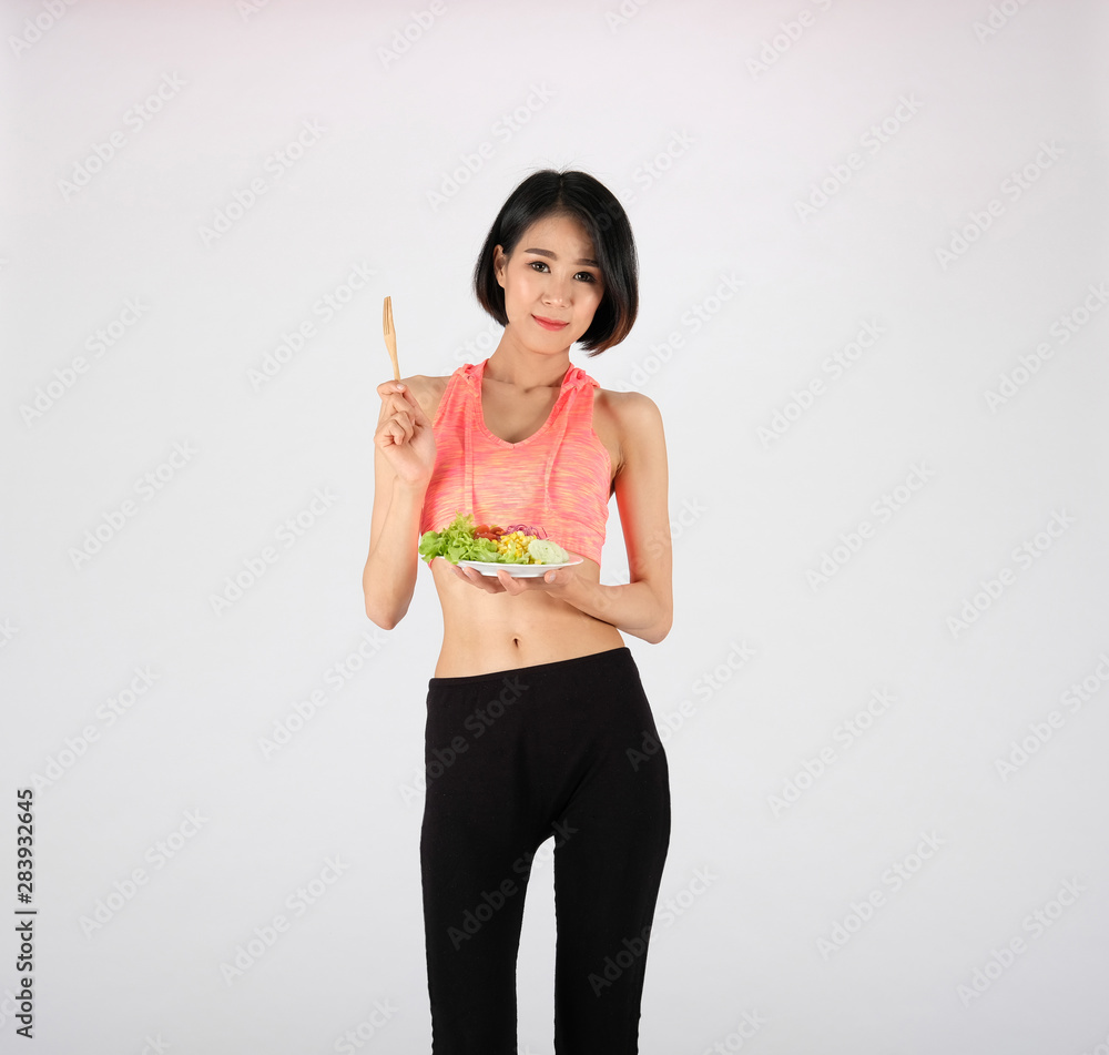 sporty fitness woman in sportswear with vegetable salad on white background. healthy sport sporty fitness woman in sportswear with vegetable salad on white background. healthy sport