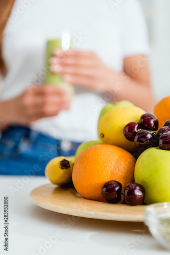 selective focus of ripe delicious fruits near girl