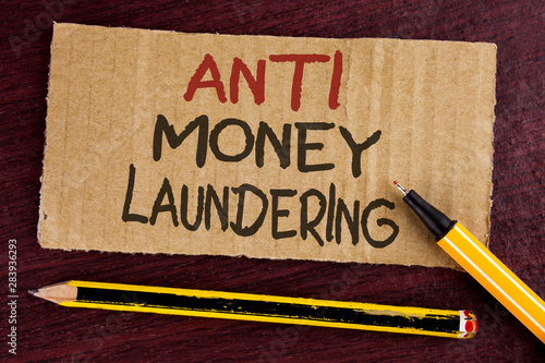 Text sign showing Anti Monay Laundring. Conceptual photo entering projects to get away dirty money and clean it written Cardboard Piece wooden background Led Pen and Pencil next to it. photo