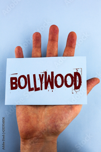 Word writing text Bollywood. Business concept for Indian cinema a source of entertainment written Sticky Note Paper placed Hand the plain background.