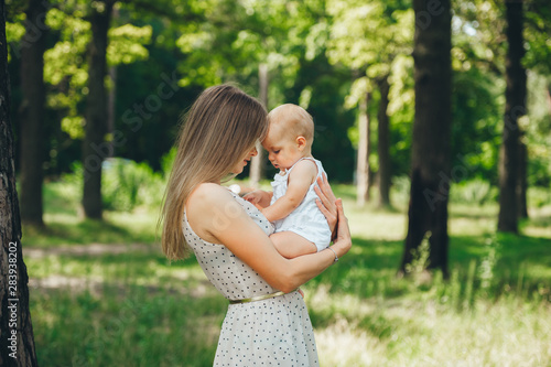 Obraz na płótnie Front view of young mother with small daughter in a summer forest. w salonie
