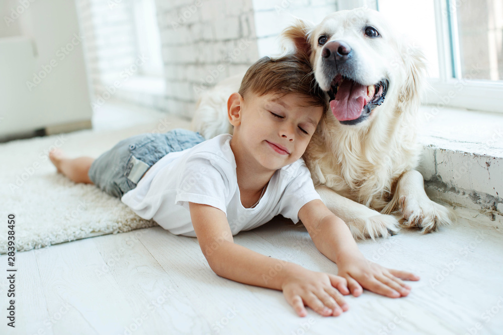 A child with a dog. Teen boy with a dog at home. A child with a dog. Teen boy with a dog at home.