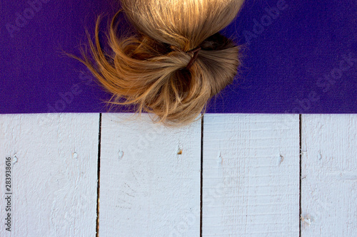 Woman practicing outdoors on violet yoga mat. Overhead close up of female hands in mudra on white wooden background. photo