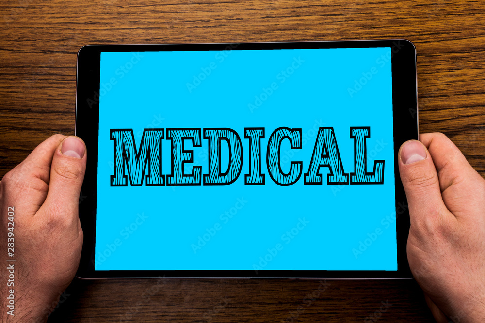Text sign showing Medical. Conceptual photo Related to science of Medicine Treatment for illness or injuries written Tablet Screen holding in Hand wooden background. Text sign showing Medical. Conceptual photo Related to science of Medicine Treatment for illness or injuries written Tablet Screen holding in Hand wooden background.