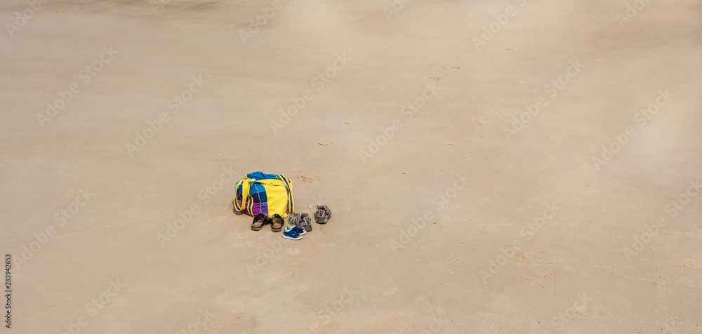 beach bag and sandals on the sand beach bag and sandals on the sand