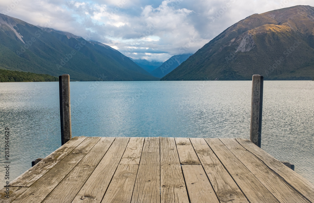 A view down a wooden jetty of the incredibly beautiful Rotoiti Lake surrounded by mountains which is part of the Nelson Lakes National Park