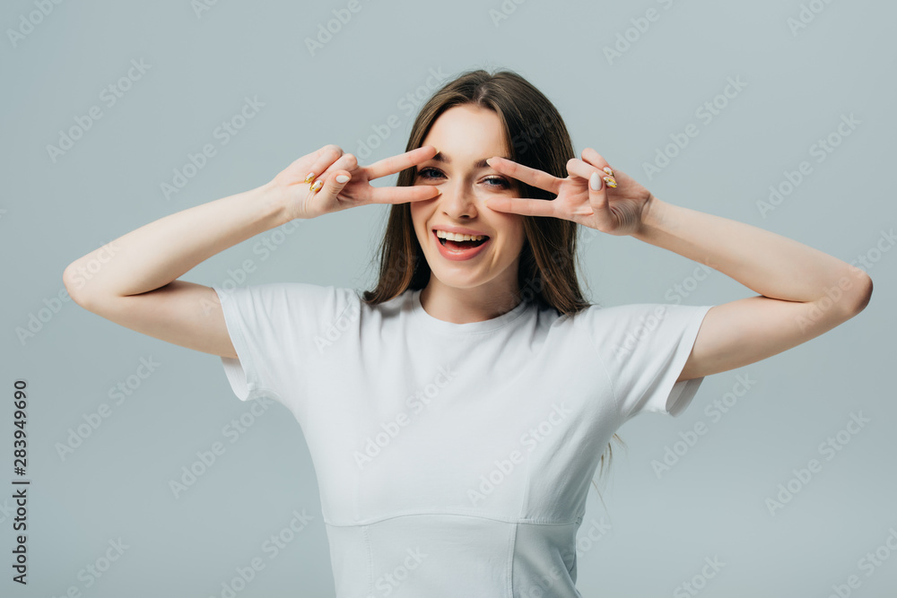 beautiful happy girl showing peace signs isolated on grey beautiful happy girl showing peace signs isolated on grey