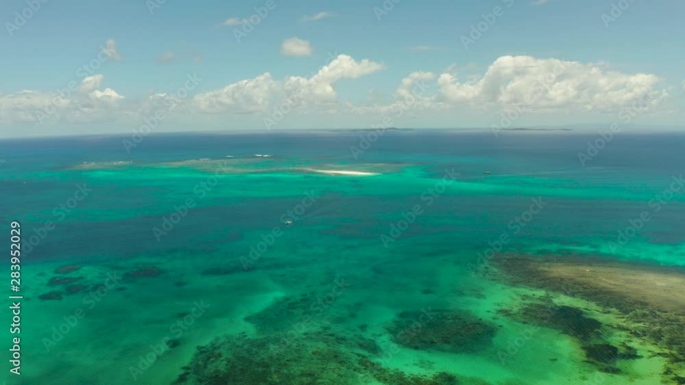 Tropical island covered with forest surrounded by an atoll and a coral reef. Summer and travel vacation concept. Siargao,Philippines. Tropical island covered with forest surrounded by an atoll and a coral reef. Summer and travel vacation concept. Siargao,Philippines.