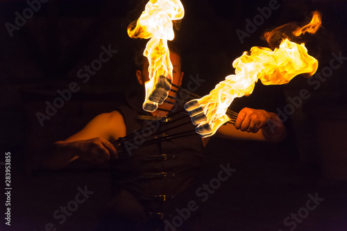 Close Up of Fire Eater Playing with Eight Burning Chopsticks at Medieval Village Festival © daniele russo