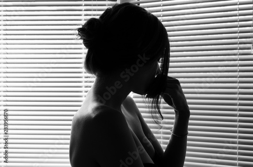 Silhouette of sad woman's head with waving hair, back light. concept depression