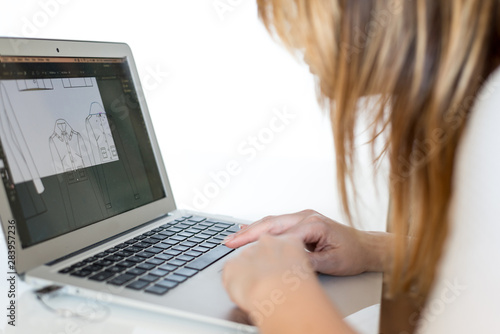 Woman using laptop to make her designs