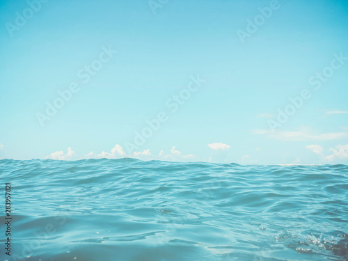 Close up of sea wave. Front view on beautiful sea wave on sandy beach. Summer sunny day, blue sky, water background