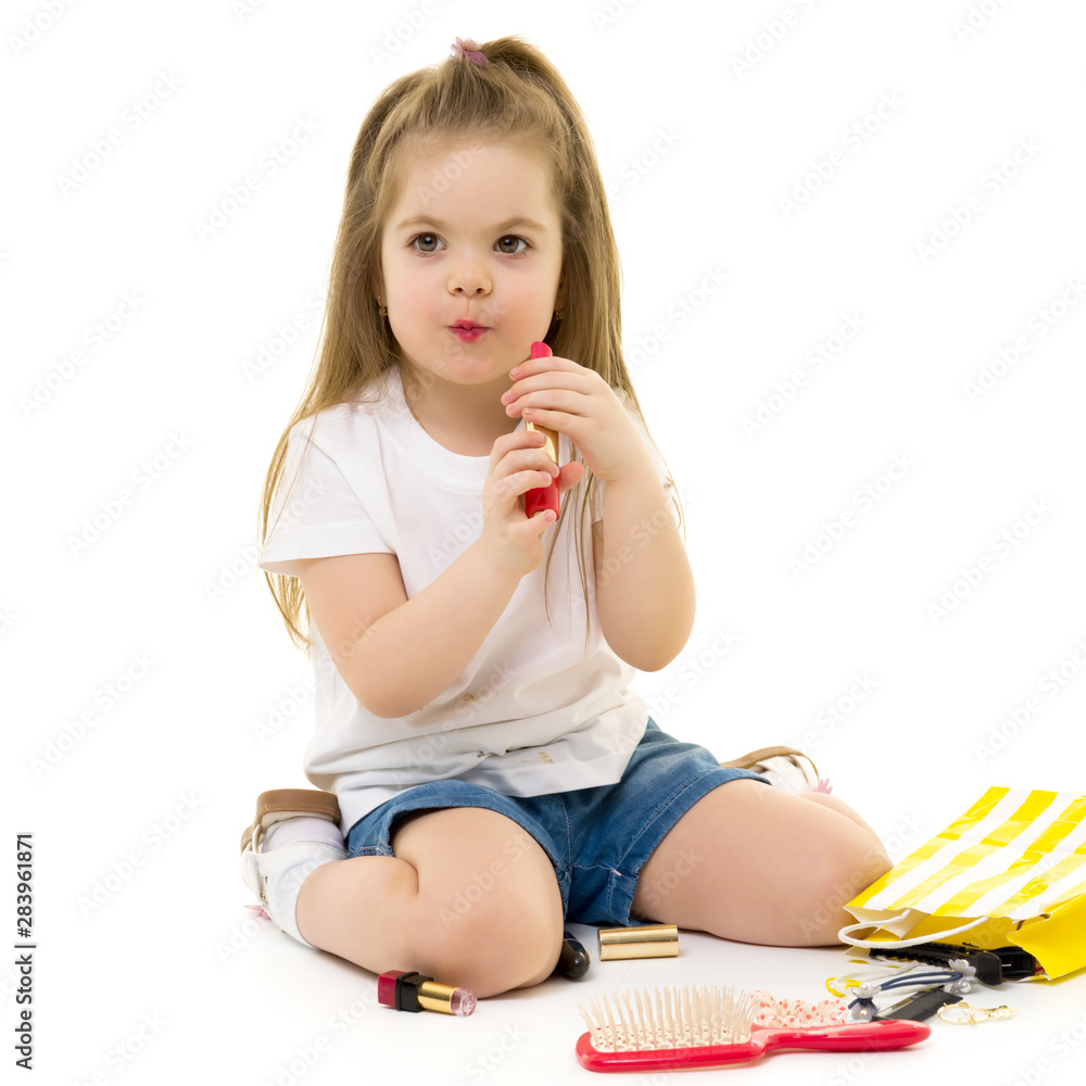 Little girl paints lips with mom's lipstick. Little girl paints lips with mom's lipstick.