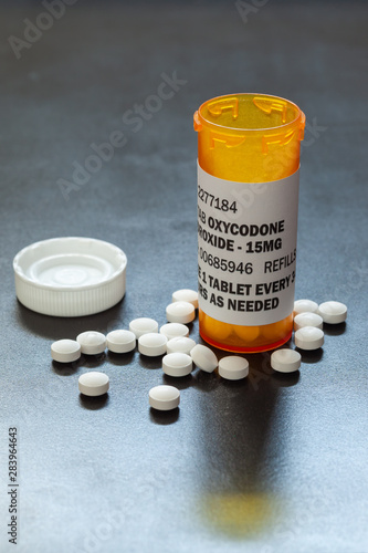 Prescription bottle with backlit Oxycodone tablets. Oxycodone is a generic prescription opioid. A concept of the opioid epidemic crisis