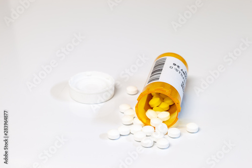 Prescription drug bottle with generic tablets or pills isolated on a white background.