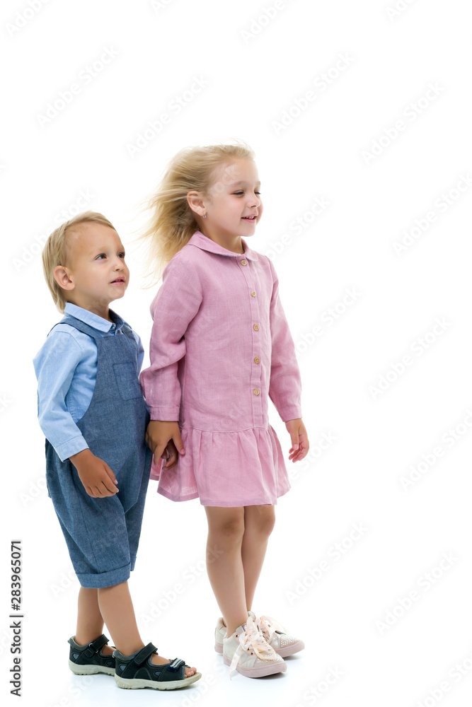 A girl and boy, brother and sister rejoices in the wind that blo A girl and boy, brother and sister rejoices in the wind that blo