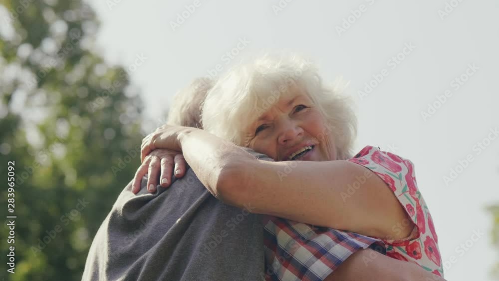 Old woman hugging her husband Old woman hugging her husband