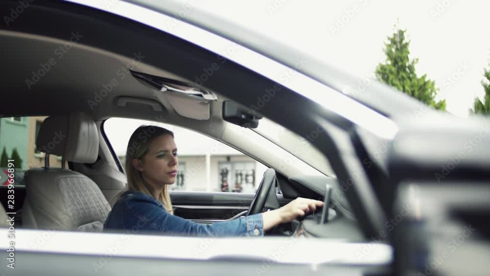 Young woman driver sitting in car, setting radio or navigation. Young woman driver sitting in car, setting radio or navigation.