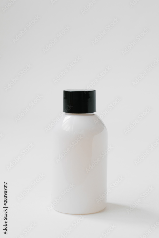 Plastic bottle with black cap for body care cosmetics or hair on white background. Side view Plastic bottle with black cap for body care cosmetics or hair on white background. Side view