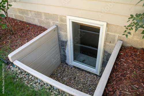 Exterior view of an egress window in a basement bedroom. These windows are required as part of the USA fire code for basement bedrooms photo