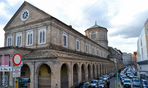 Edificio con arcos y calle con trafico en Roma de día