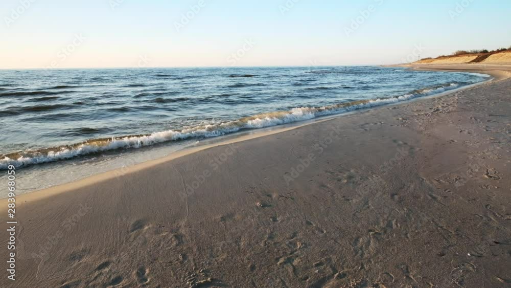 Baltic sea at sunset, sandy beach, soft waves and mild water overflows over the sandy back - slo-mo Baltic sea at sunset, sandy beach, soft waves and mild water overflows over the sandy back - slo-mo