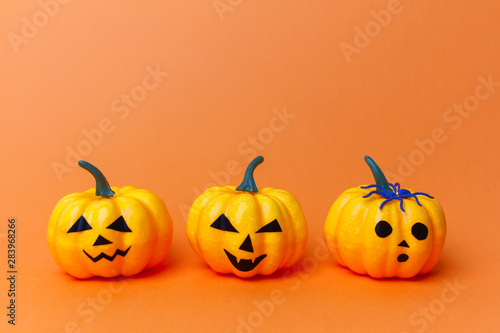 Traditional halloween pumpkins with scary faces - symbol of the holiday of the eve of All Saints Day on an orange background.