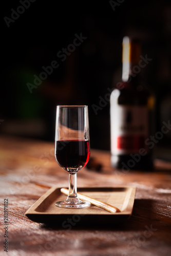 Glass of port wine on wooden table and over dark background