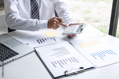 Businessman accountant working analyzing and calculating expense annual financial report balance sheet statement, doing finance making notes on report, Financing Accounting Banking Concept