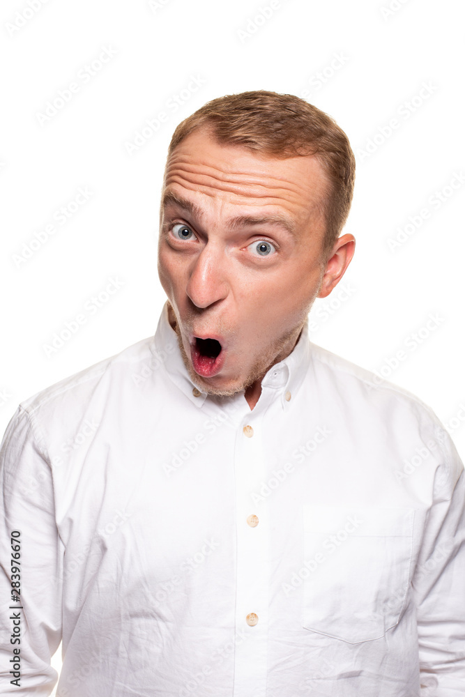 Vertical shot of stupefied stunned shocked young male keeps mouth widely opened, being surprised and very emotional, expresses great surprisment. Vertical shot of stupefied stunned shocked young male keeps mouth widely opened, being surprised and very emotional, expresses great surprisment.