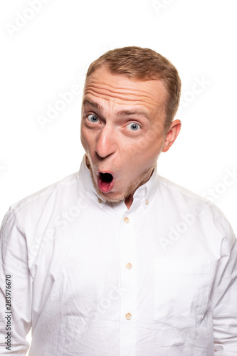 Vertical shot of stupefied stunned shocked young male keeps mouth widely opened, being surprised and very emotional, expresses great surprisment.