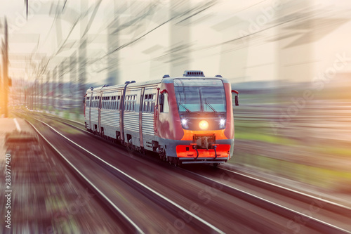 Wall Mural Passenger diesel train travels by rail motion blur effect.