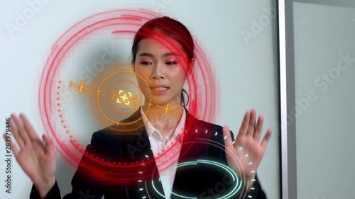 A woman moves around abstract HUD components in a hi-tech virtual environment to optimize a futuristic system photo