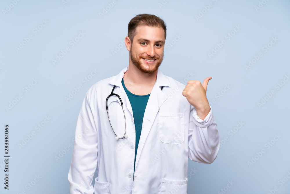 Handsome doctor man over blue wall pointing to the side to present a product Handsome doctor man over blue wall pointing to the side to present a product