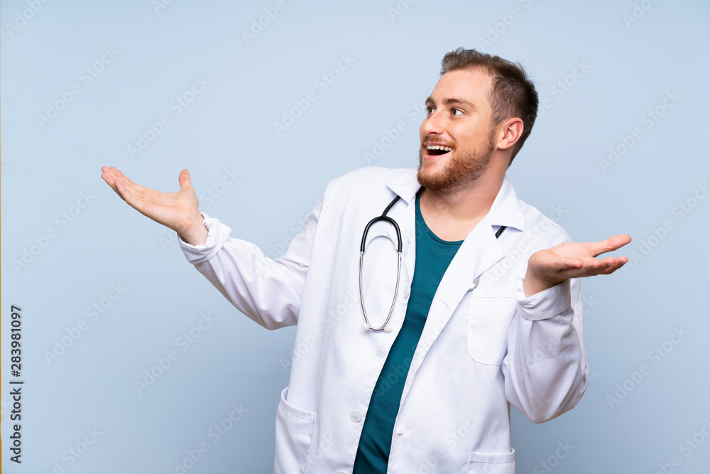 Handsome doctor man over blue wall with surprise facial expression Handsome doctor man over blue wall with surprise facial expression